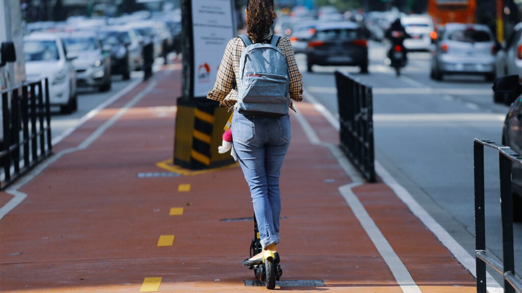 kvinde der kører på cykelstien på et elektrisk løbehjul