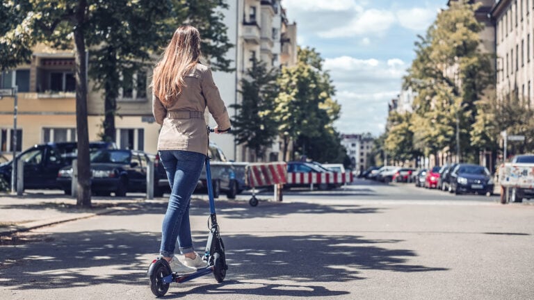 kvinde kører på elektrisk løbehjul på gaden